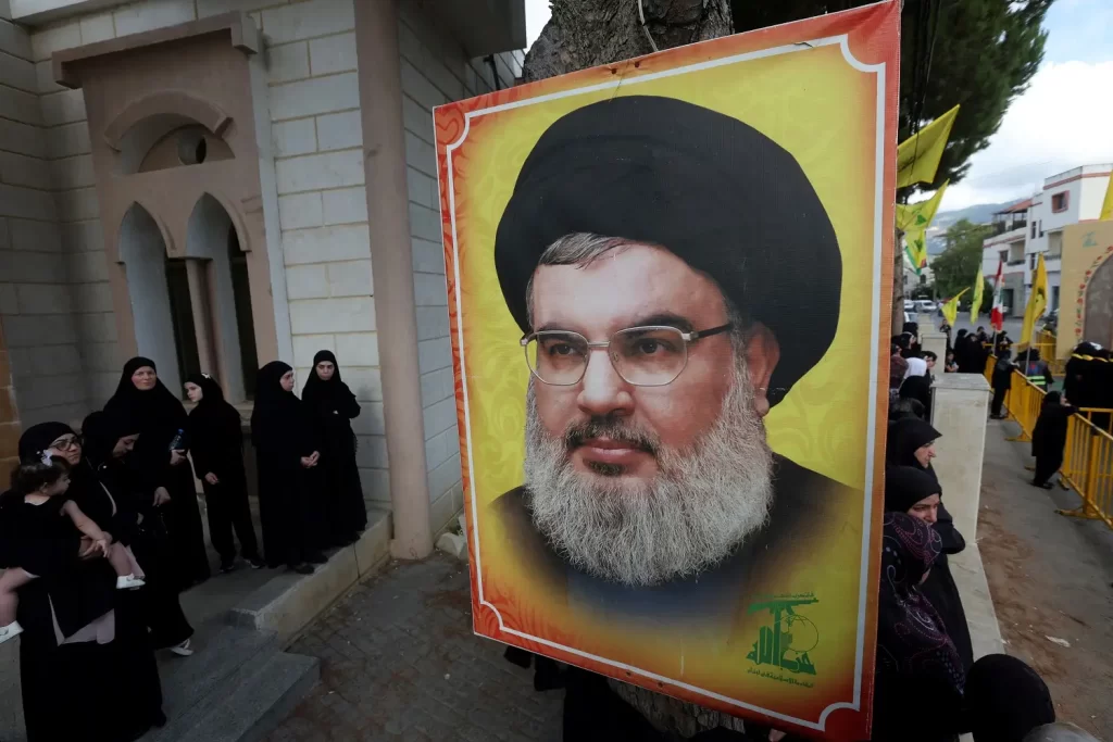 Pessoas se reúnem em torno de uma imagem do líder do Hezbollah, Sayyed Hassan Nasrallah