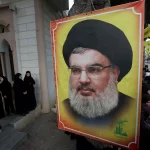 Pessoas se reúnem em torno de uma imagem do líder do Hezbollah, Sayyed Hassan Nasrallah